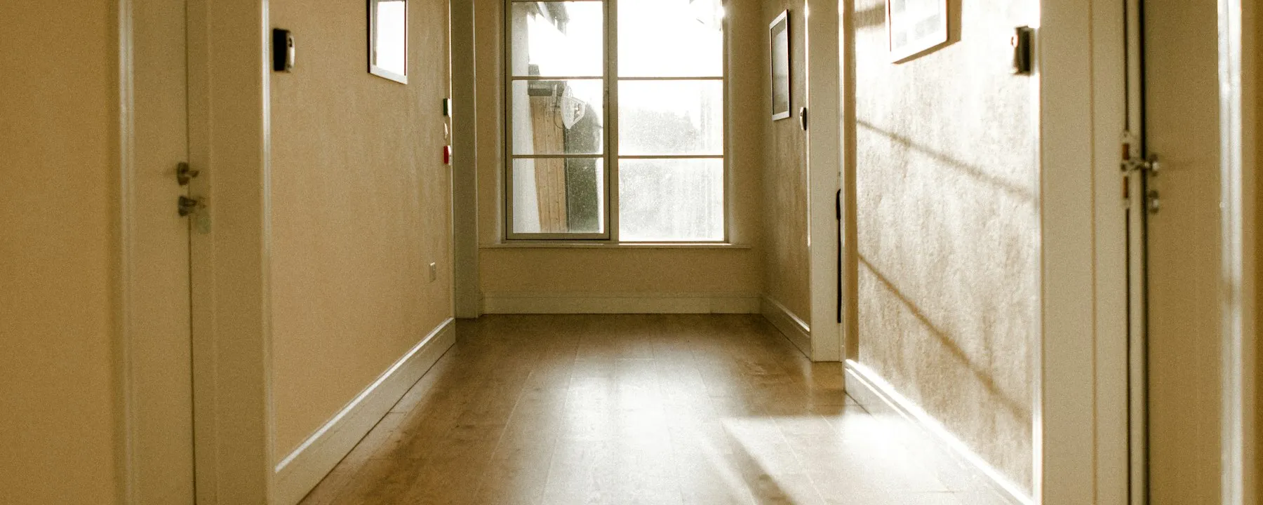 Sunlight filling a warm, naturally lit interior hallway